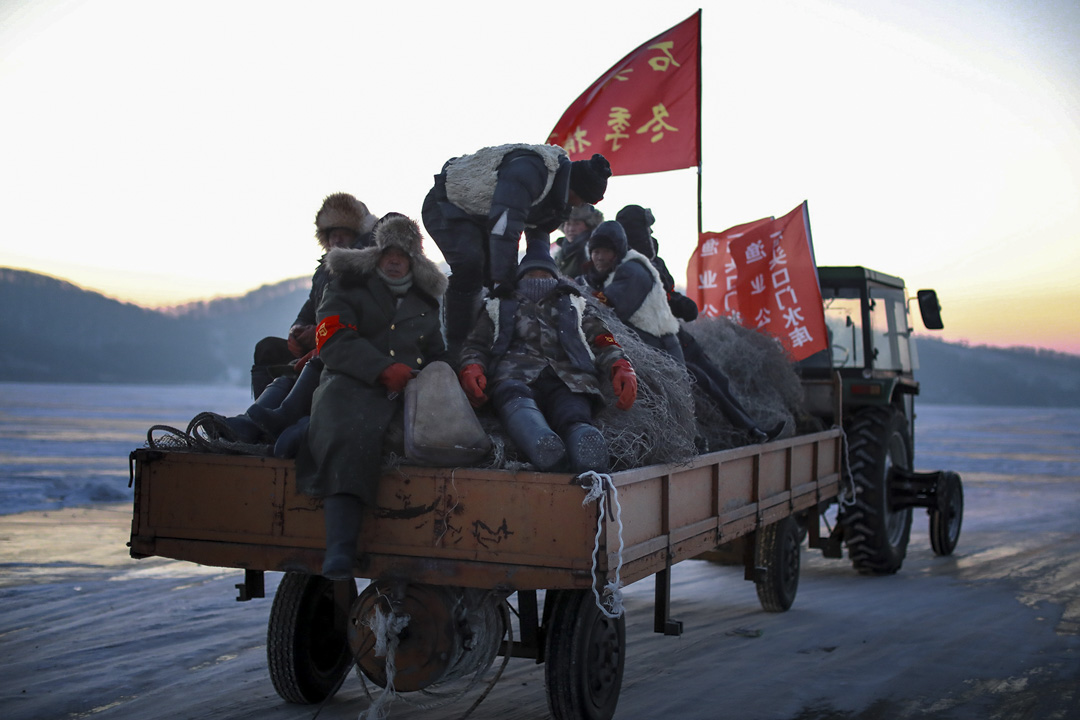 攝氏零下24攝氏，漁民穿上厚厚的大衣，乘坐拖拉機在冰上行走。