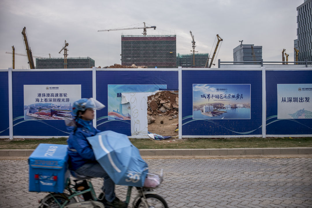  深圳蛇口一個巨型工地前，外賣快遞車駛過。