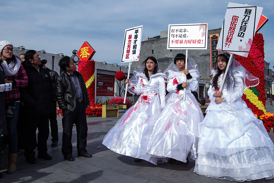 2012年2月14日情人节，三名女孩在北京市街头穿上血淋淋的婚纱，为家庭暴力受害者抗议，左为李麦子，右为韦婷婷。