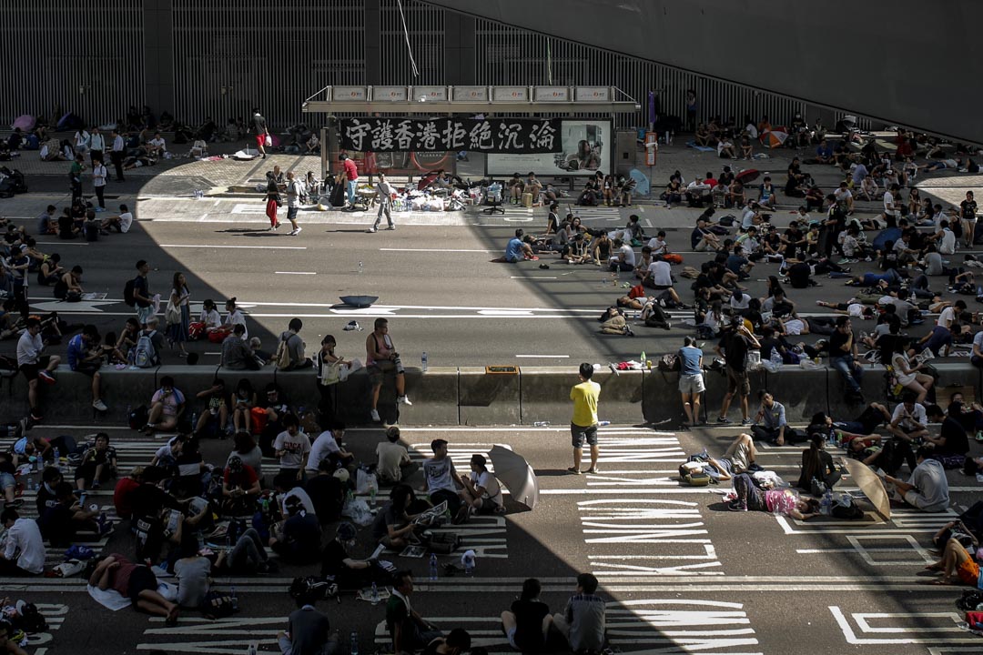 2014年9月29日，雨伞运动第二天，占领者坐在金钟夏悫道。