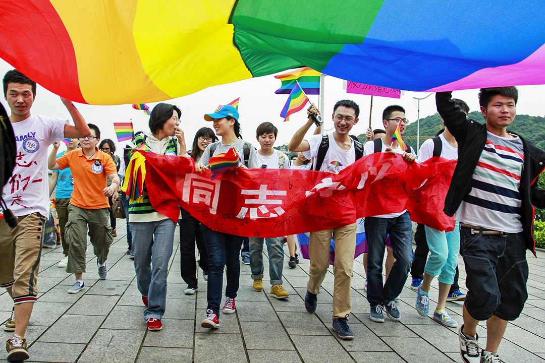 2013年5月17日，中國湖南省長沙市舉行的反歧視遊行中，年輕人舉著彩虹旗,，大約有一百人聚集在一起參加遊行。