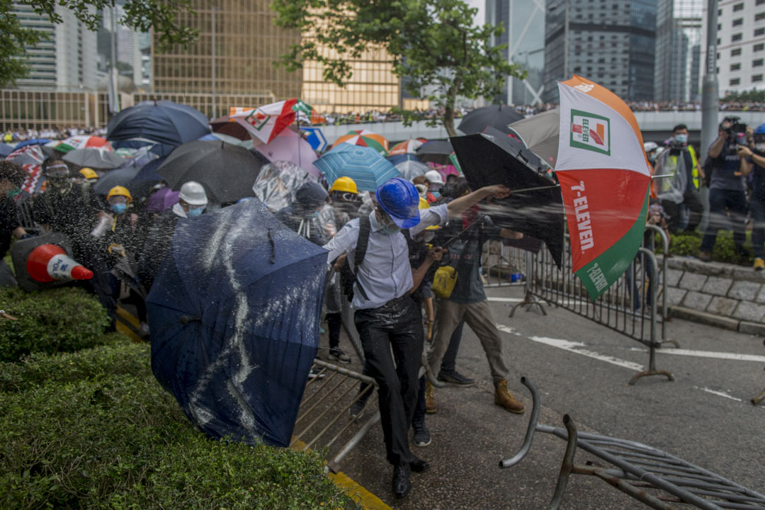 2019年6月12日，一名示威者在舉傘扺抗警方的楜椒噴霧。