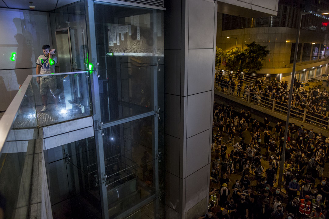 2019年6月26日，示威者包围警察总部，期间一名怀疑便衣警员的男子被围堵在一个角落，被示威者用灯光照射。