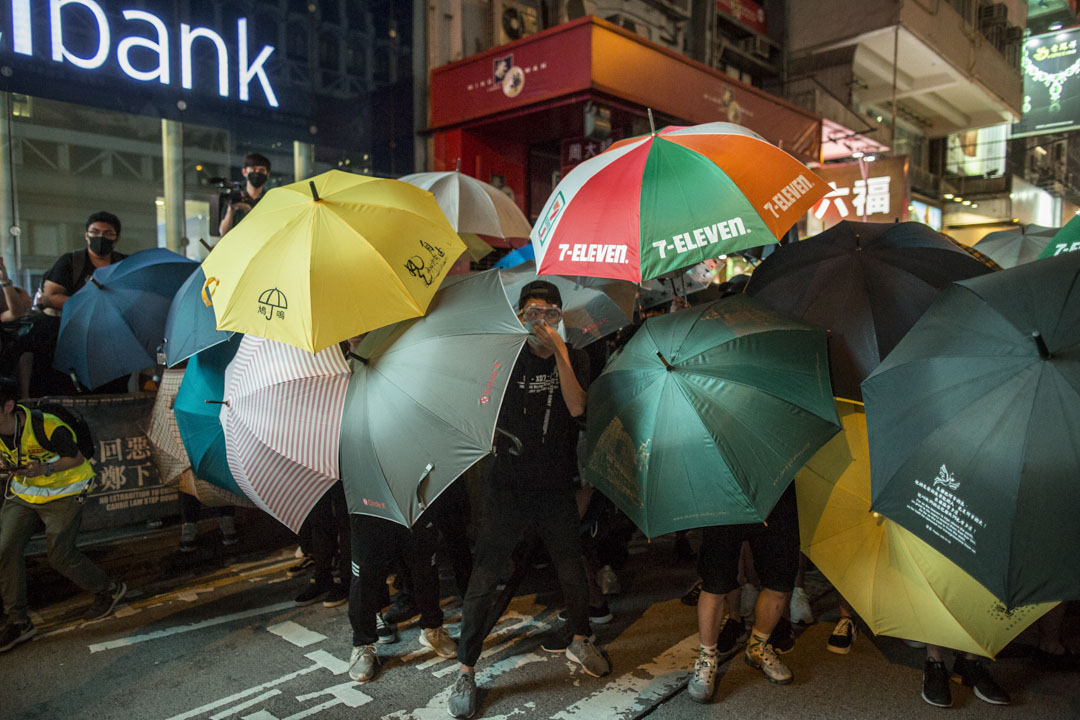 2019年7月7日晚上，警方在旺角弥敦道清场，示威者以雨伞抵挡。