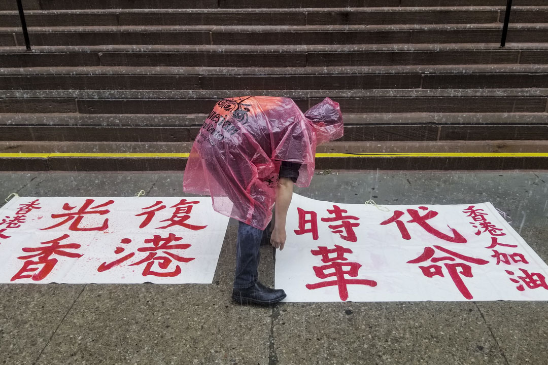  写有“光复香港，时代革命”的白布在雨中。