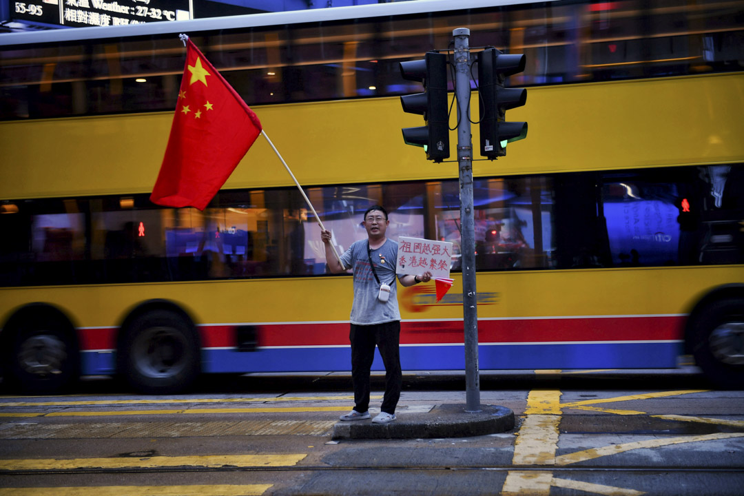 2019年8月26日，一位市民在香港中环挥动中国国旗。