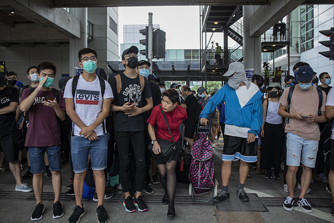 2019年9月1日，示威者包围机场，意图瘫痪机场运作，一名空中服务员穿过示威的人群。