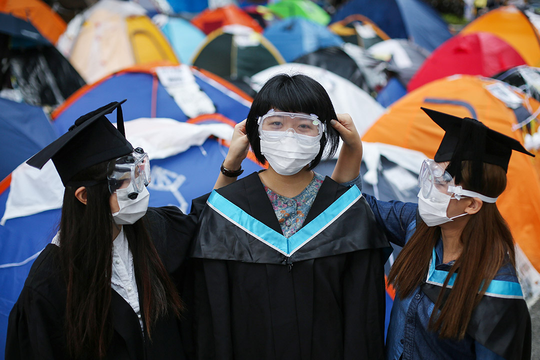 2014年10月25日，大學的畢業生於雨傘運動金鐘佔領區合影。