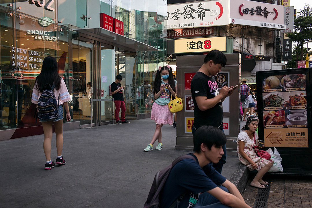 2016年8月8日，人们在台北西门看他们的智能手机。