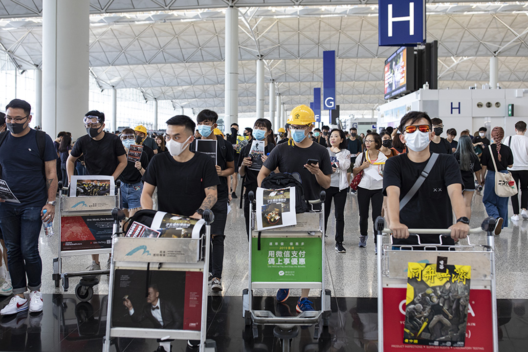 2019年8月12日，示威者在香港国际机场内示威，向旅客派发传单及呼叫口号。