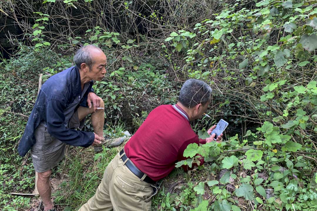 黃瓜冲村村民李太蘭和曾參與文革平反的幹部王德佳向天坑下探望。