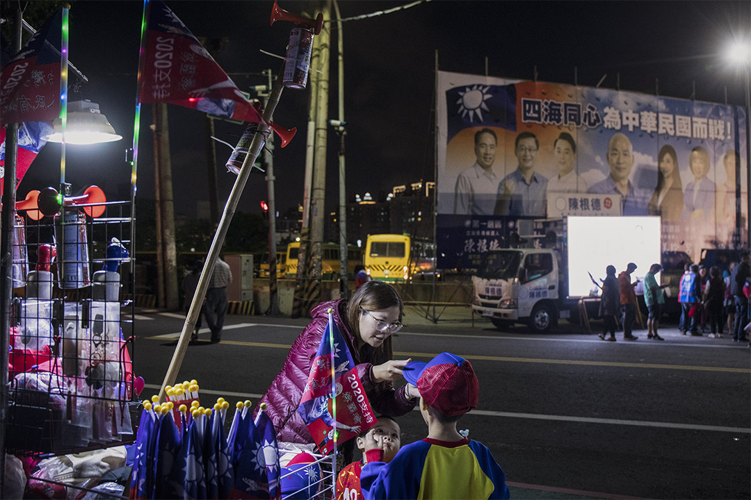 2019年11月2日，桃园的造势晚会上，一名参与者为孩子买帽子。