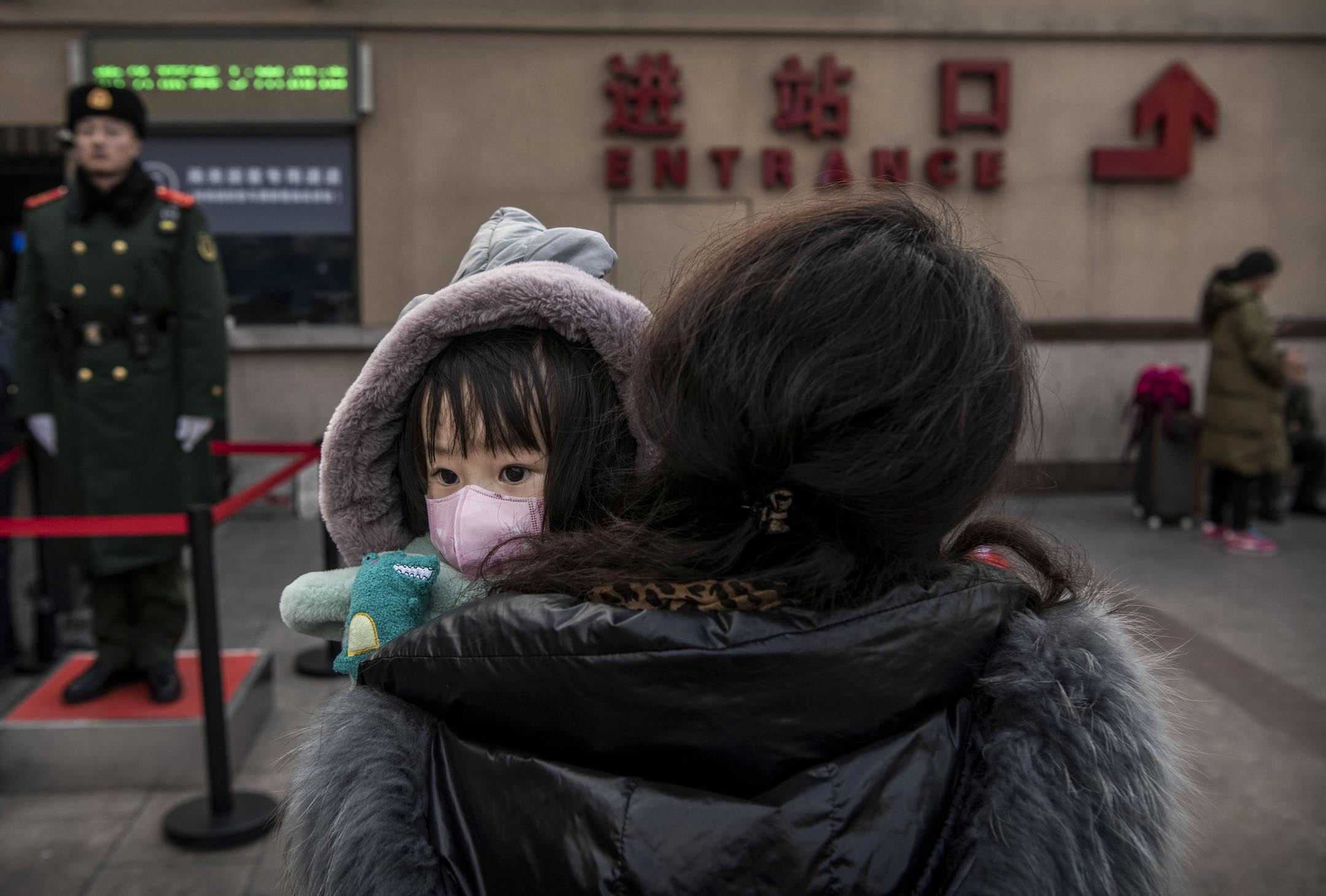 2020年1月21日，在春節夕的北京火車站，一名中國女孩戴著防護口罩，等候登車。