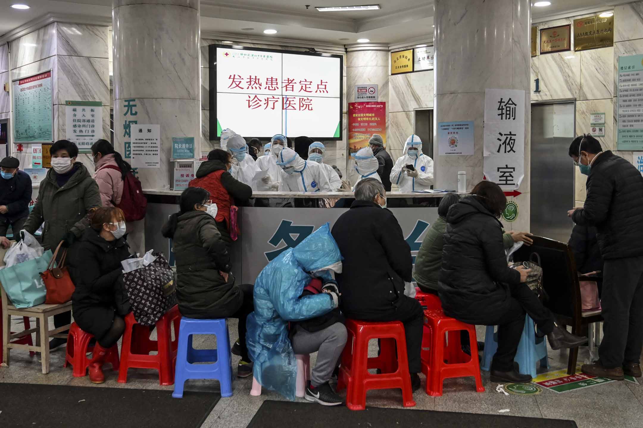 2020年1月24日，武汉市红十字会医院，穿著防护服的医务人员及等候的病人。