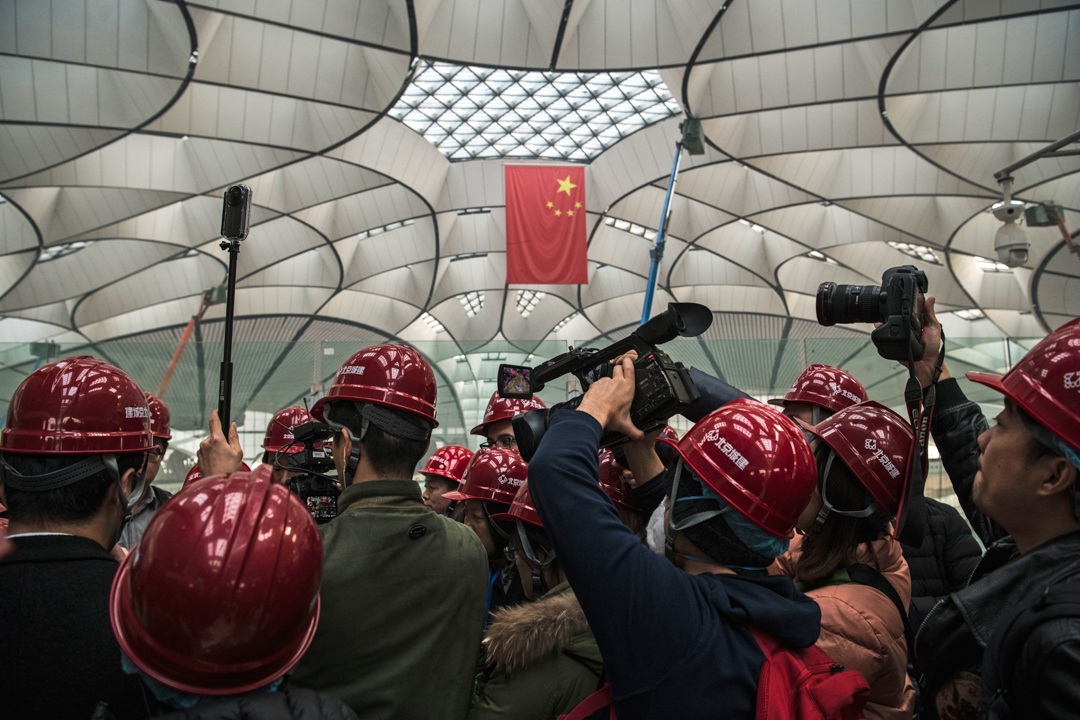 2019年3月1日，一群记者正在访问兴建中的北京大兴国际机场的一名工程师。