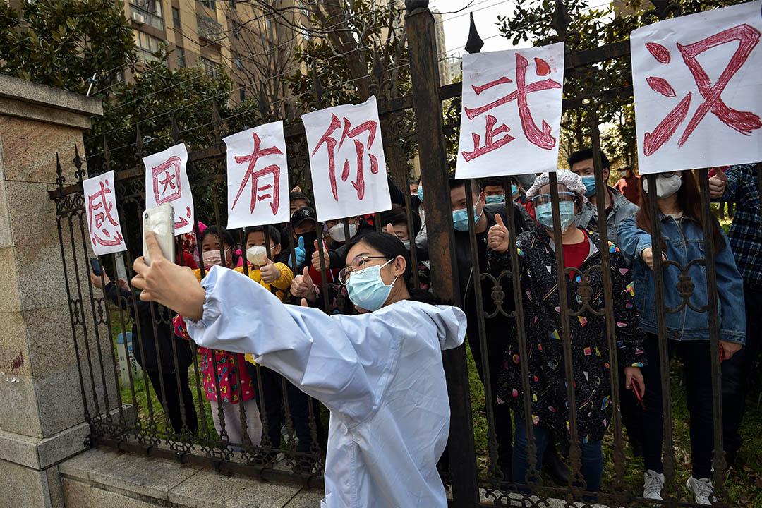 2020年3月18日中国中部湖北省武汉市，一名来自云南医疗队的人员与当地人自拍。