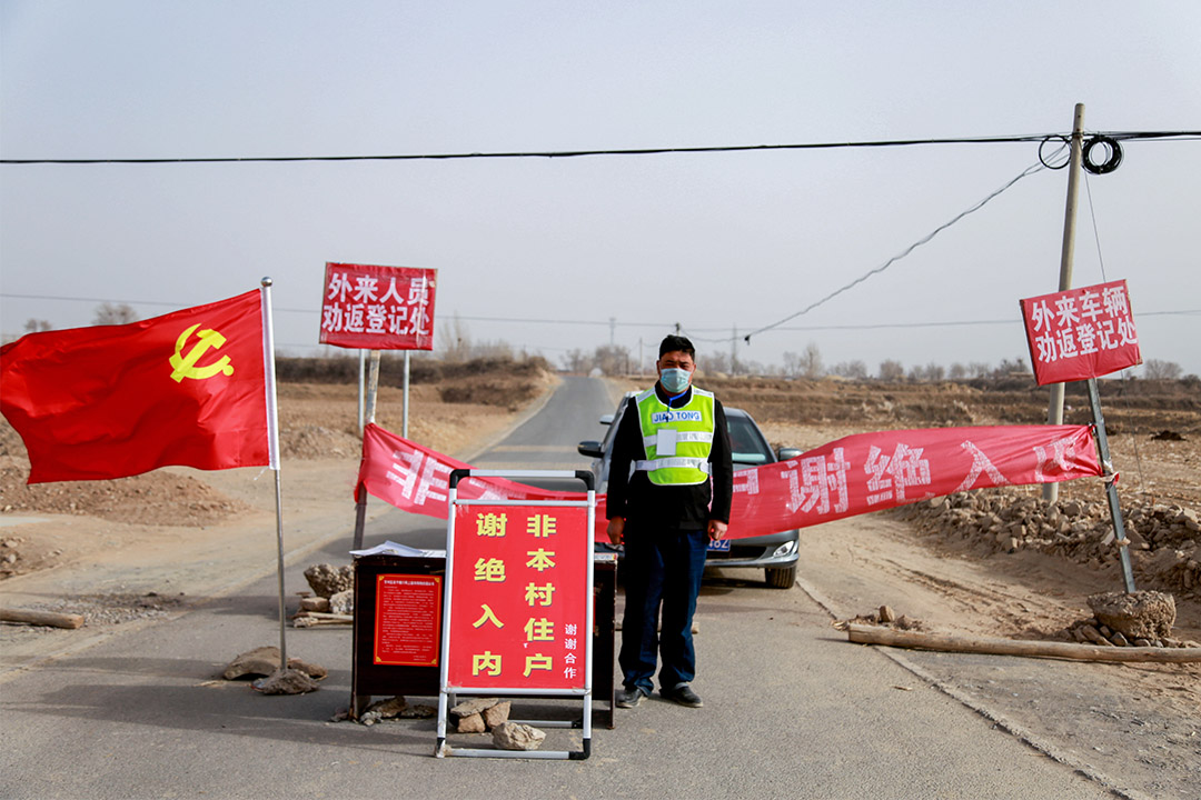 2020年2月18日，一名守卫在中国甘肃省农村的入口处，以阻止新型冠状病毒扩散。