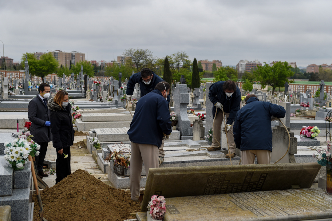 2020年4月7日，西班牙马德里一个墓地，一家人正在为他们因2019冠状病毒去世的亲人送葬。