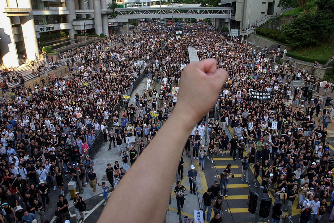 2003年7月1日，成千上万的人在香港街上游行，抗议廿三条立法。