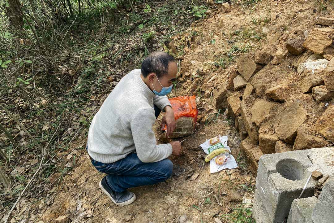 鄢小文在大兒子鄢成的墓地前拜祭。