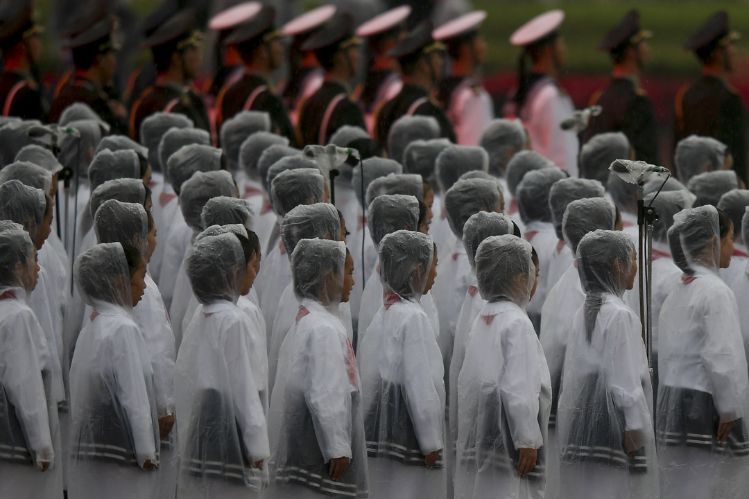 2013年10月1日，中国北京，穿上雨衣的学生在天安门广场上表演，庆祝中华人民共和国建国64周年。