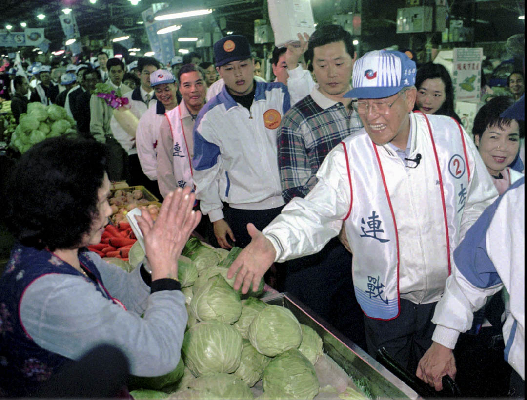 1996年3月8日，李登辉总统参观菜市场时，与一个商贩握手。