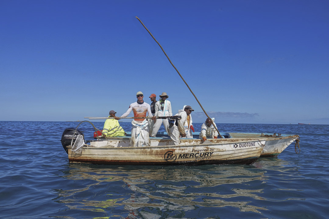 漁民在「若潮號」擱淺的附近海域清理油污。