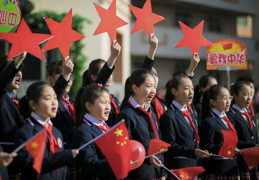 2019年2月28日，中国内蒙古自治区呼和浩特市，学生们在表演名为“我和我的祖国”的歌曲时举著中国国旗。