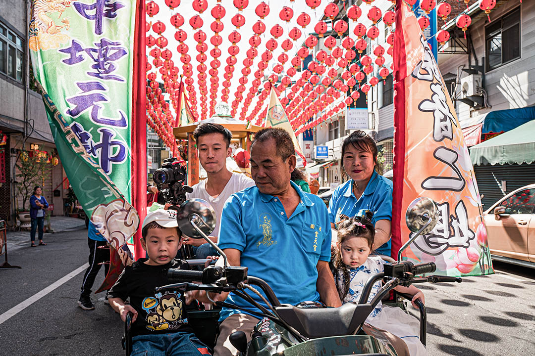 一名埔里鎮民帶著孩子參與祭典。