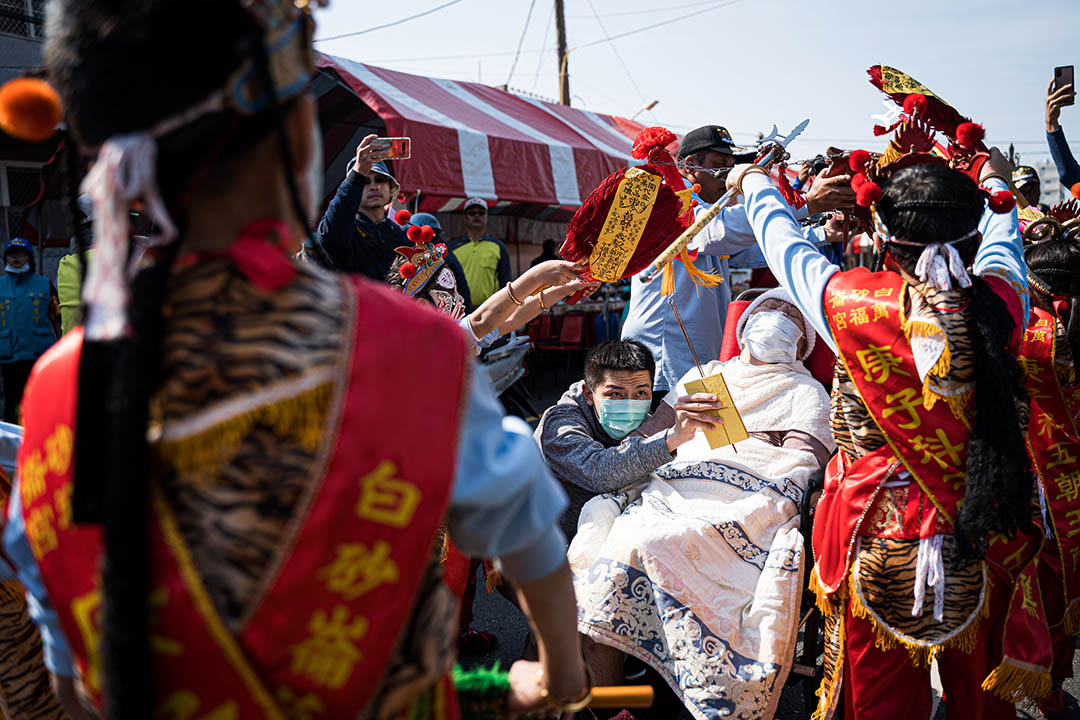 一名病重的婦女，被親友帶到祭典現場，盼望能獲神明庇佑、得以康復。