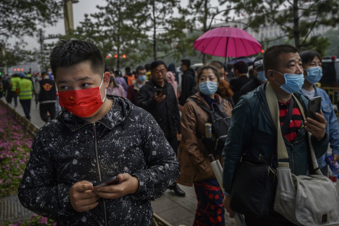 2020年10月，北京，一名戴上紅色口罩的男子在街道上走過。