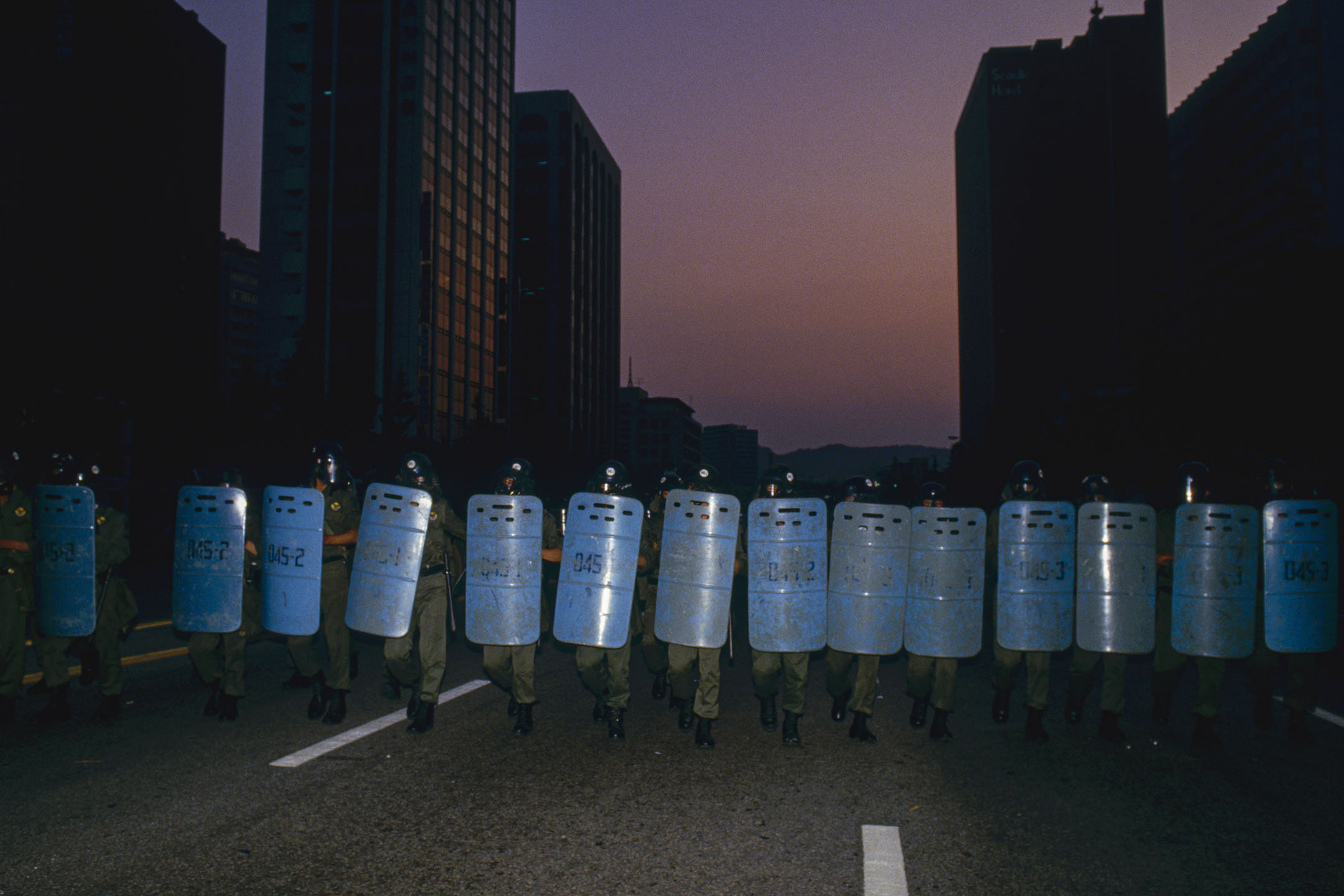 1987年6月26日，一次學生示威遊行中，韓國防暴警察走在漢城的街道上。 