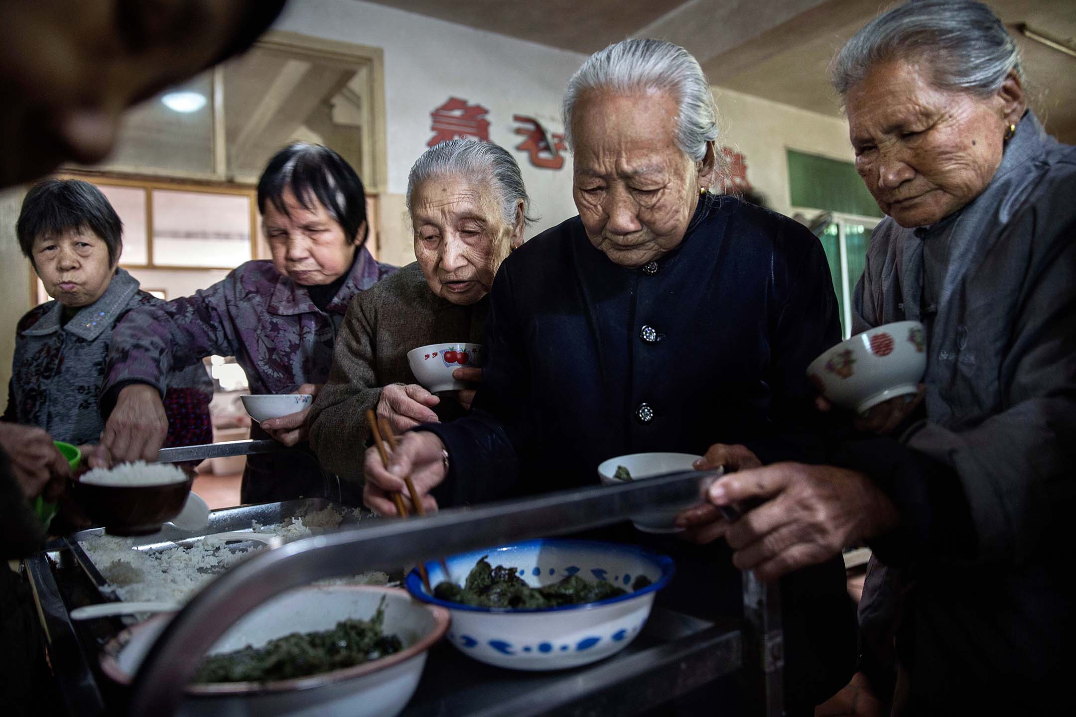 2016年3月17日中国福建沙县，年长的居民在寺庙内的老人院吃午餐。