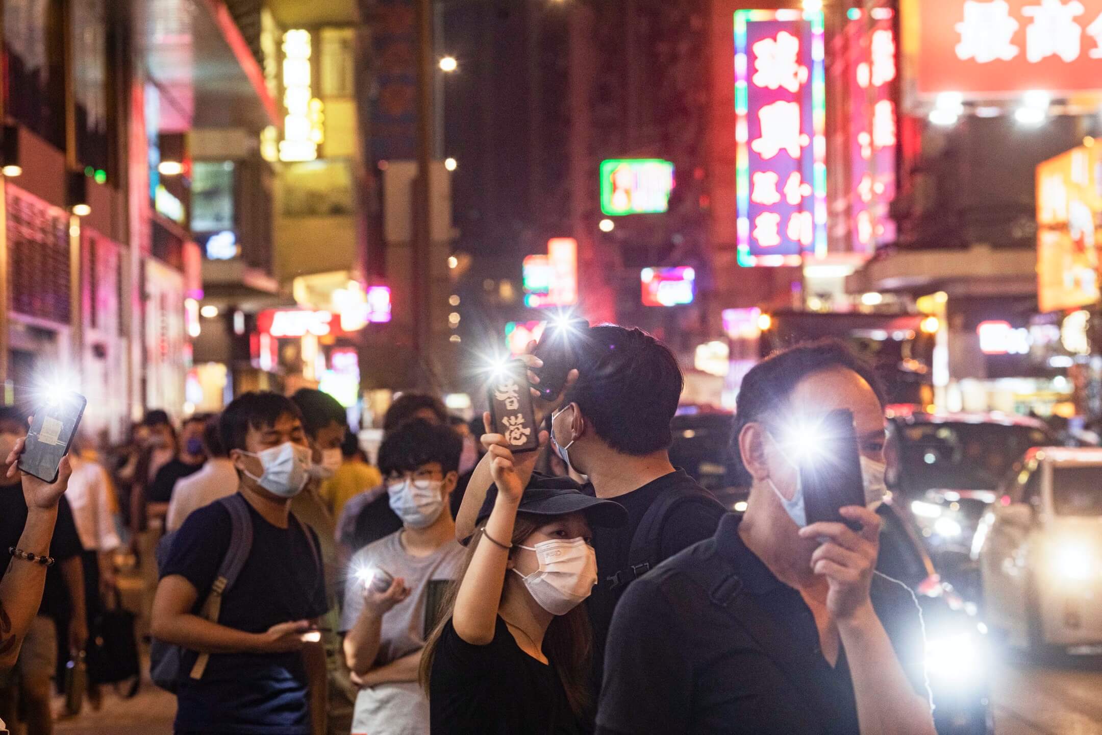 2021年6月4日，市民在旺角街头举起手机灯，悼念六四事件。摄：陈焯𪸩/端传媒