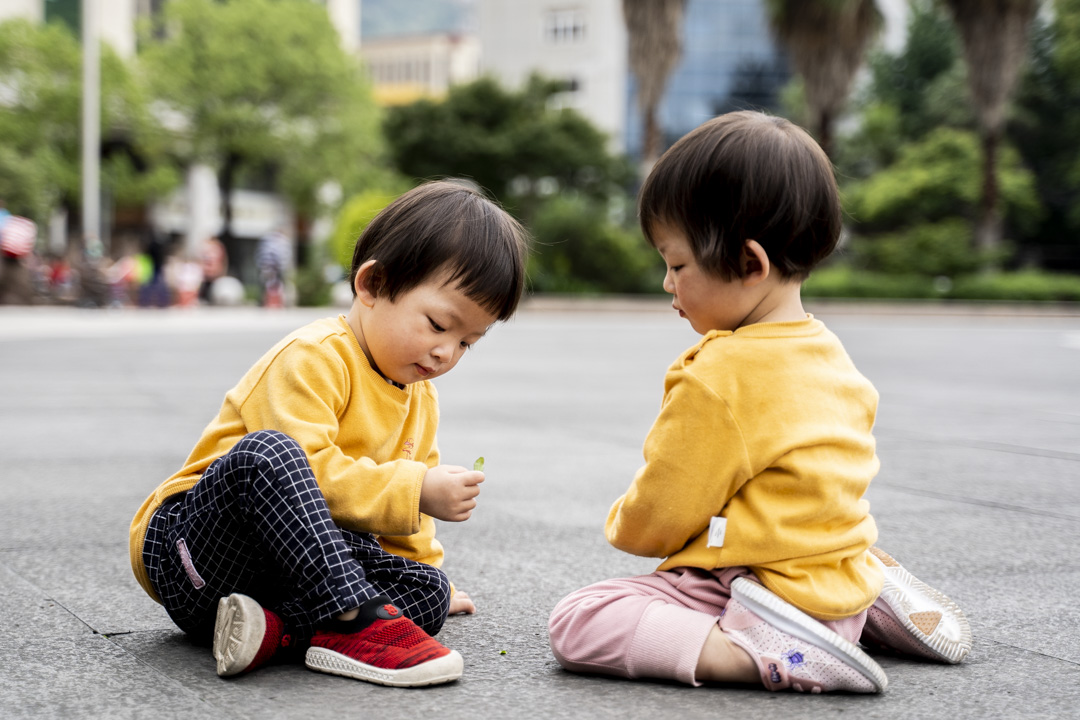 2021年5月25日，浙江青田火车站广场，一对双胞胎姊妹在玩耍。摄：林文清/端传媒