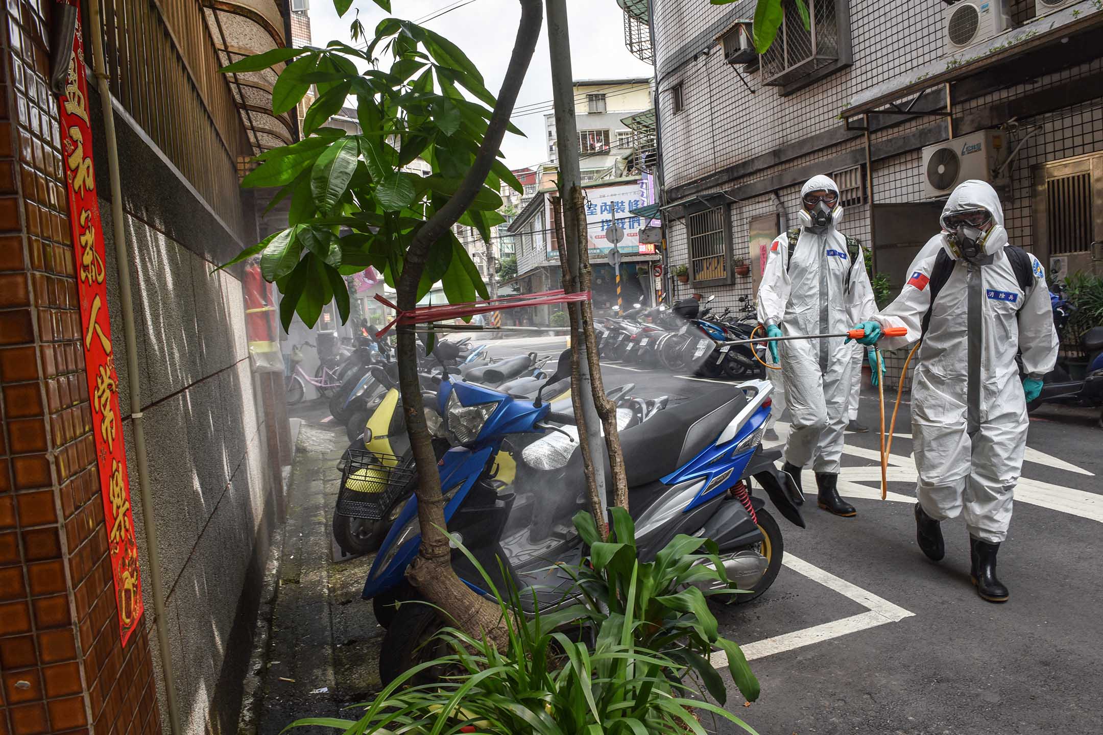 2021年5月26日台湾台北，身穿防护服的军人在街道上消毒。