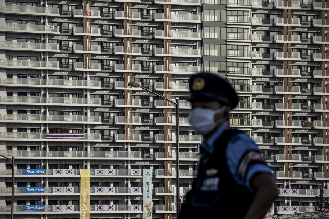 2021年7月19日，东京一名警察在东京奥运会运动员村的住宿楼旁站岗。