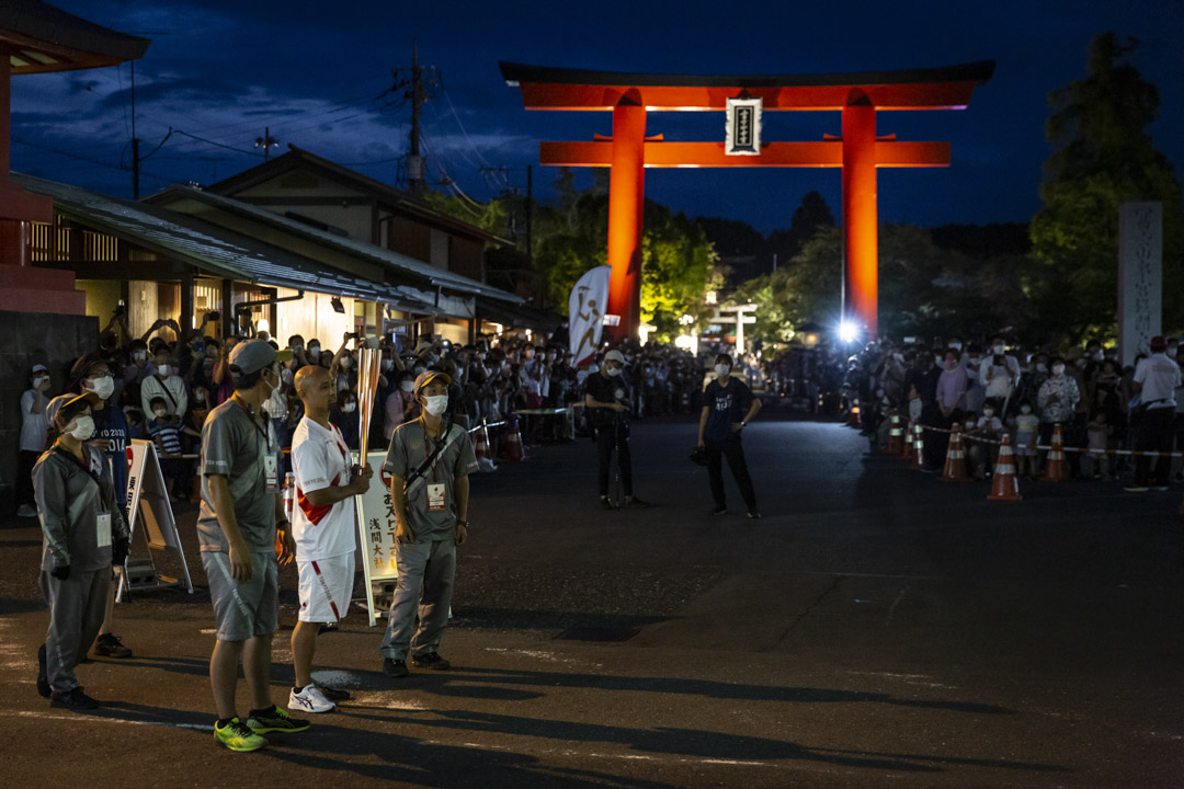 2021年6月25日，日本富士宫举行的东京奥运会火炬传递期间，一名火炬手在接力点等待。