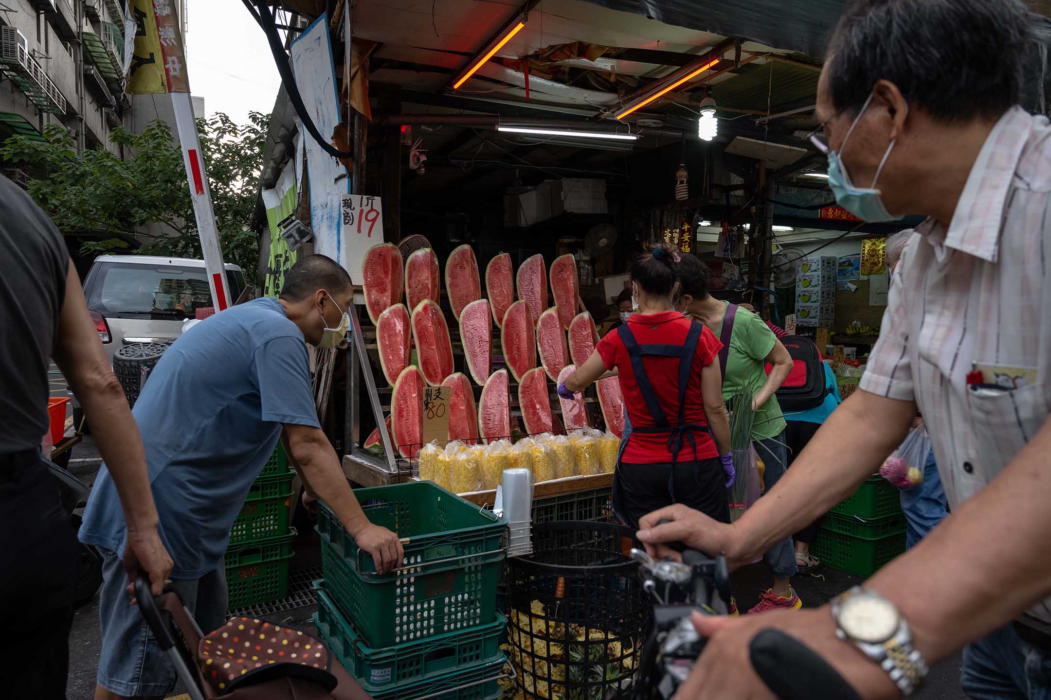  2021年5月27日台湾台北，戴着口罩的人们在市场上购买食物。