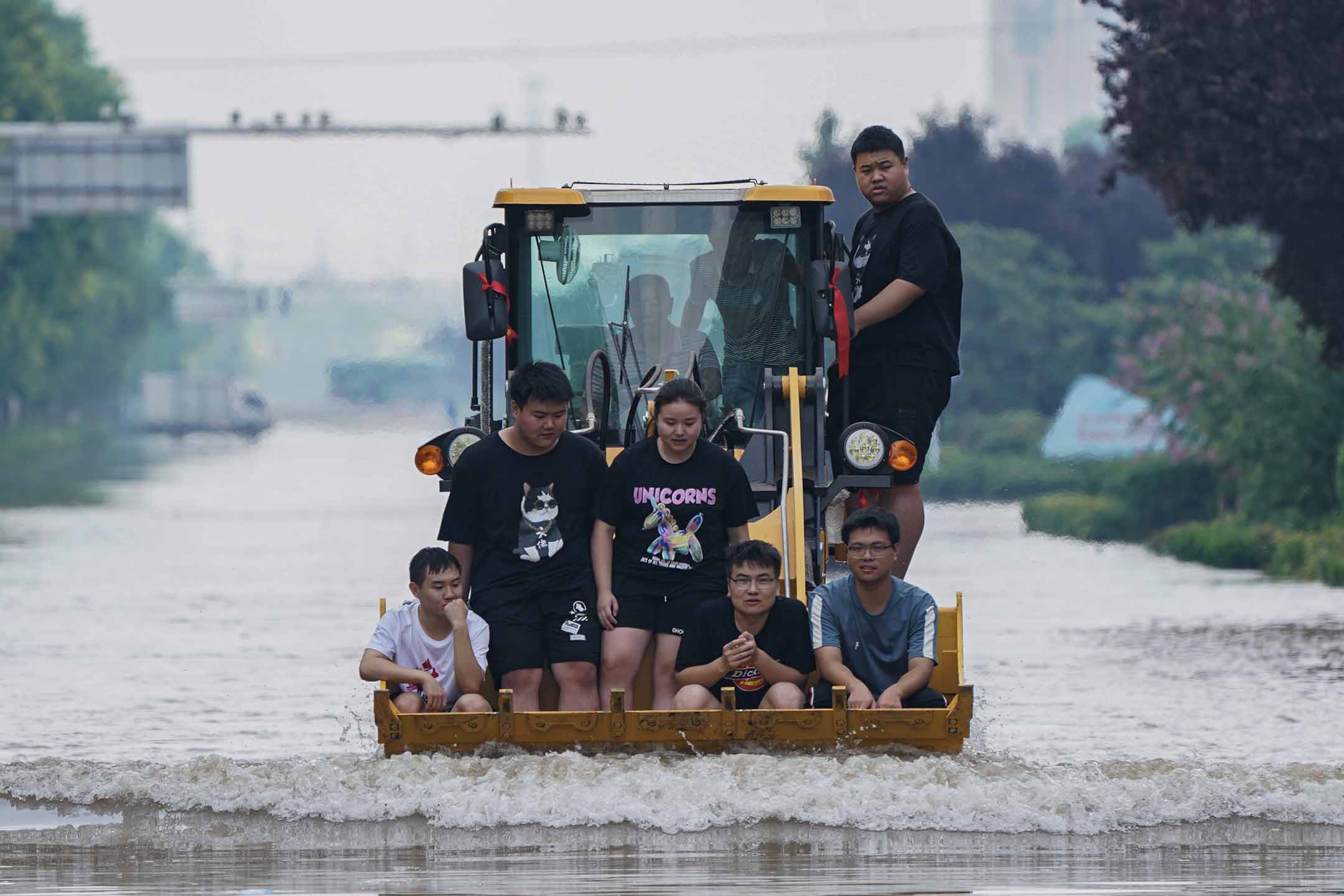 2021年7月24日中国河南省新乡市，救援人员使用装载机疏散当地居民。