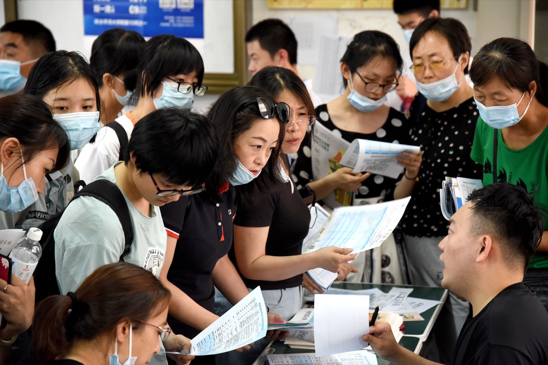 高考生与家长们在一场大学招生咨询会上了解入学信息。