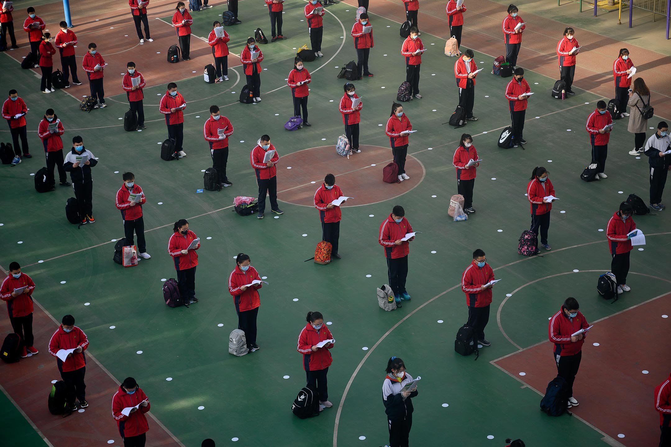 2020年4月25日中国太原，中学重新开放的第一天，戴着口罩的学生在操场上读书。