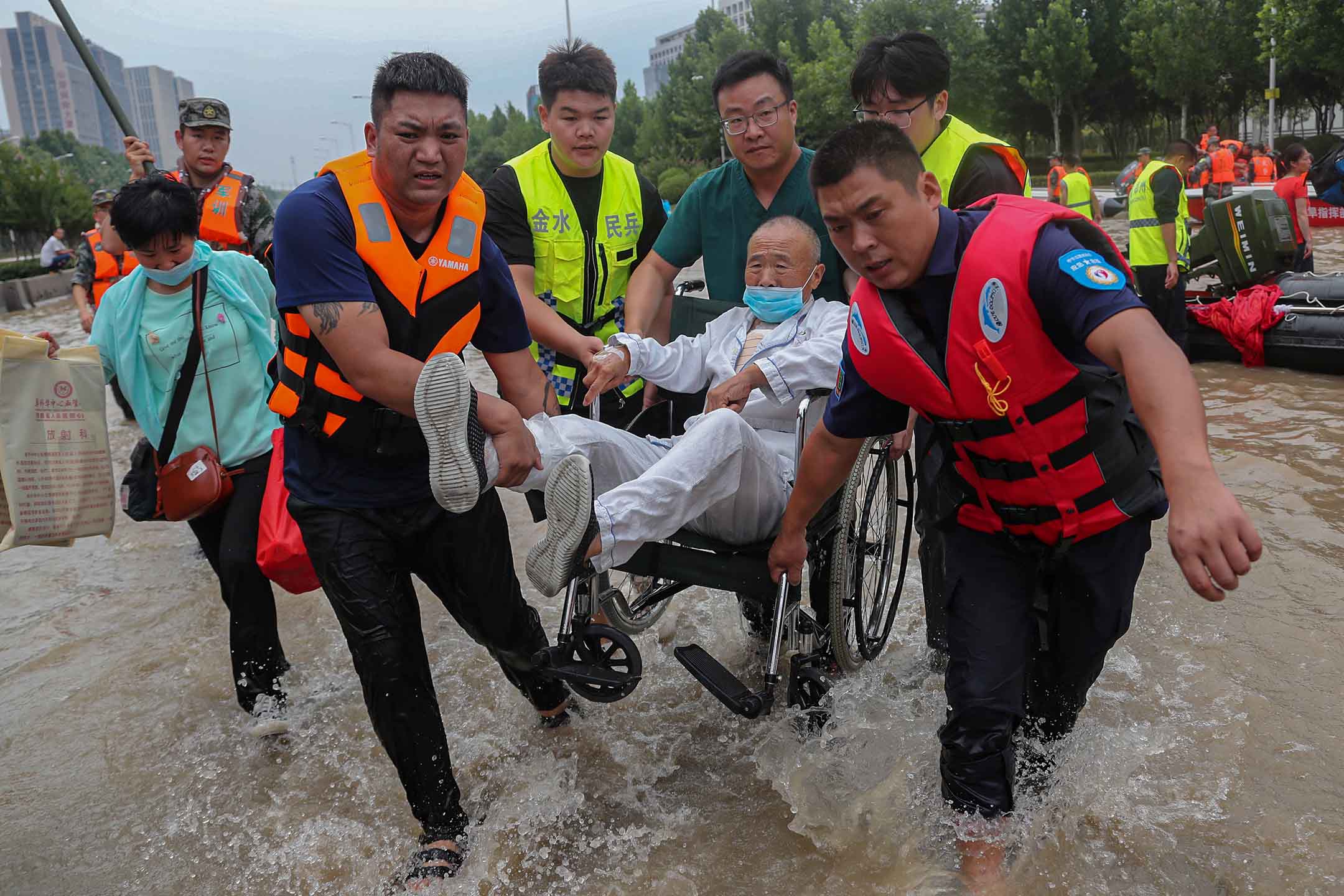 2021年7月22日中国河南省郑州市，救援人员在医院拯救一名坐在轮椅上的患者。