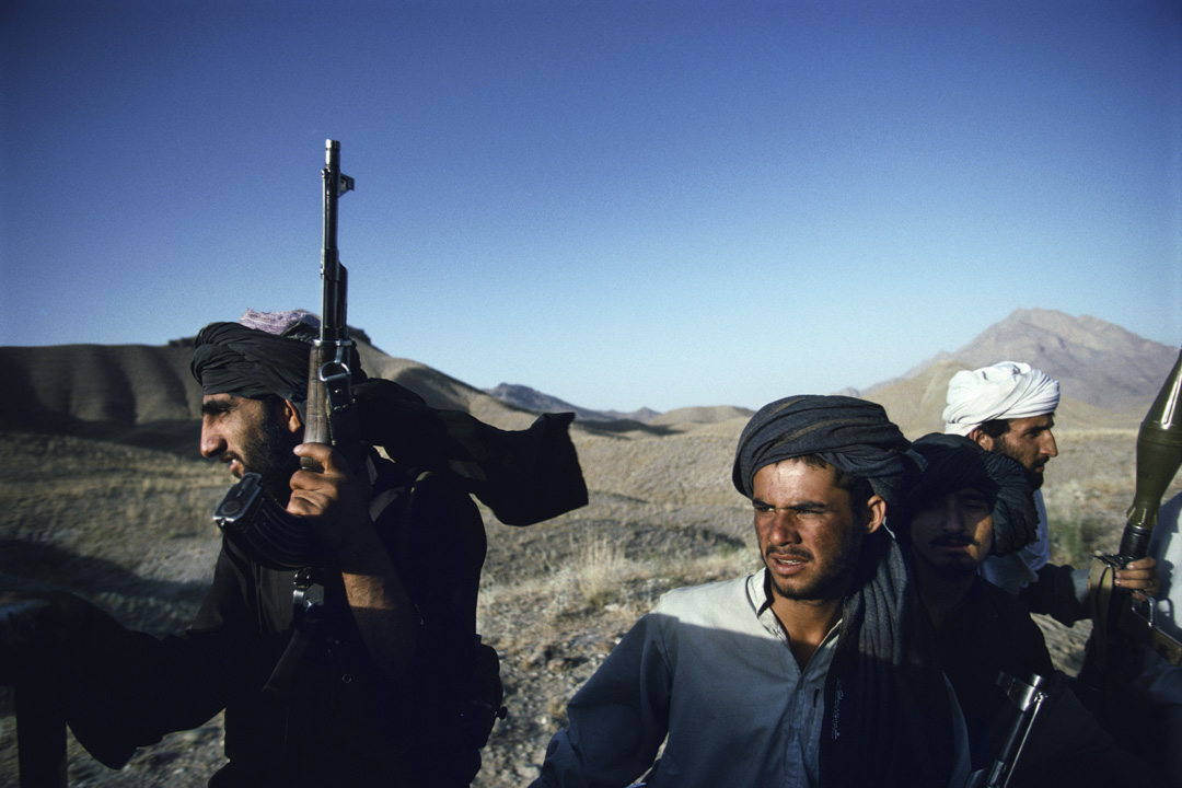 1996年，身份不明的武装塔利班士兵在阿富汗喀布尔郊外乘坐一辆皮卡车。