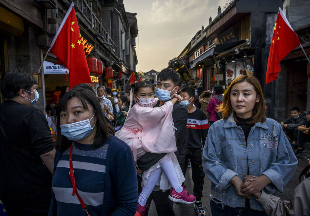 2020年10月3日，北京的黄金周假期，一名中国男子带著身著传统服装的女儿在商业和旅游区散步。