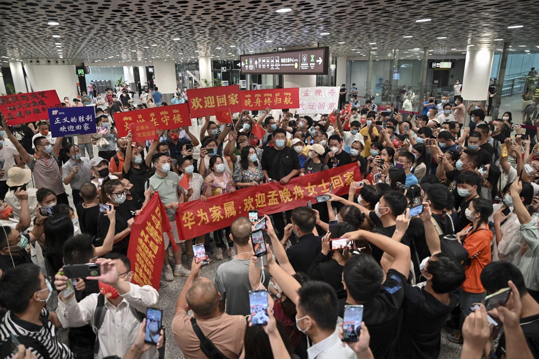 2021年9月25日，深圳人们在深圳宝安国际机场等待孟晚舟回国，举著写有“欢迎回家孟晚舟”的横幅和标语牌。