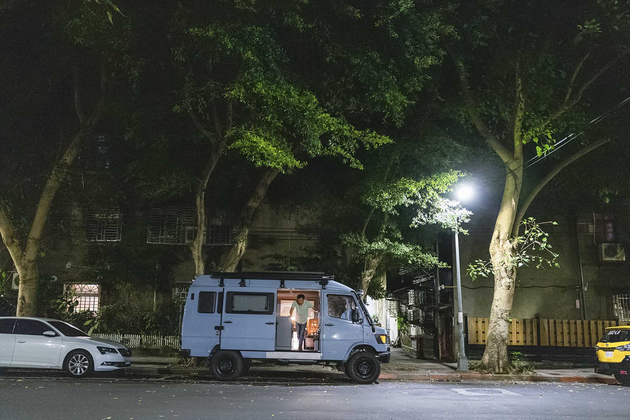 谢至德驾驶他的露营车，停泊在台北的街道。