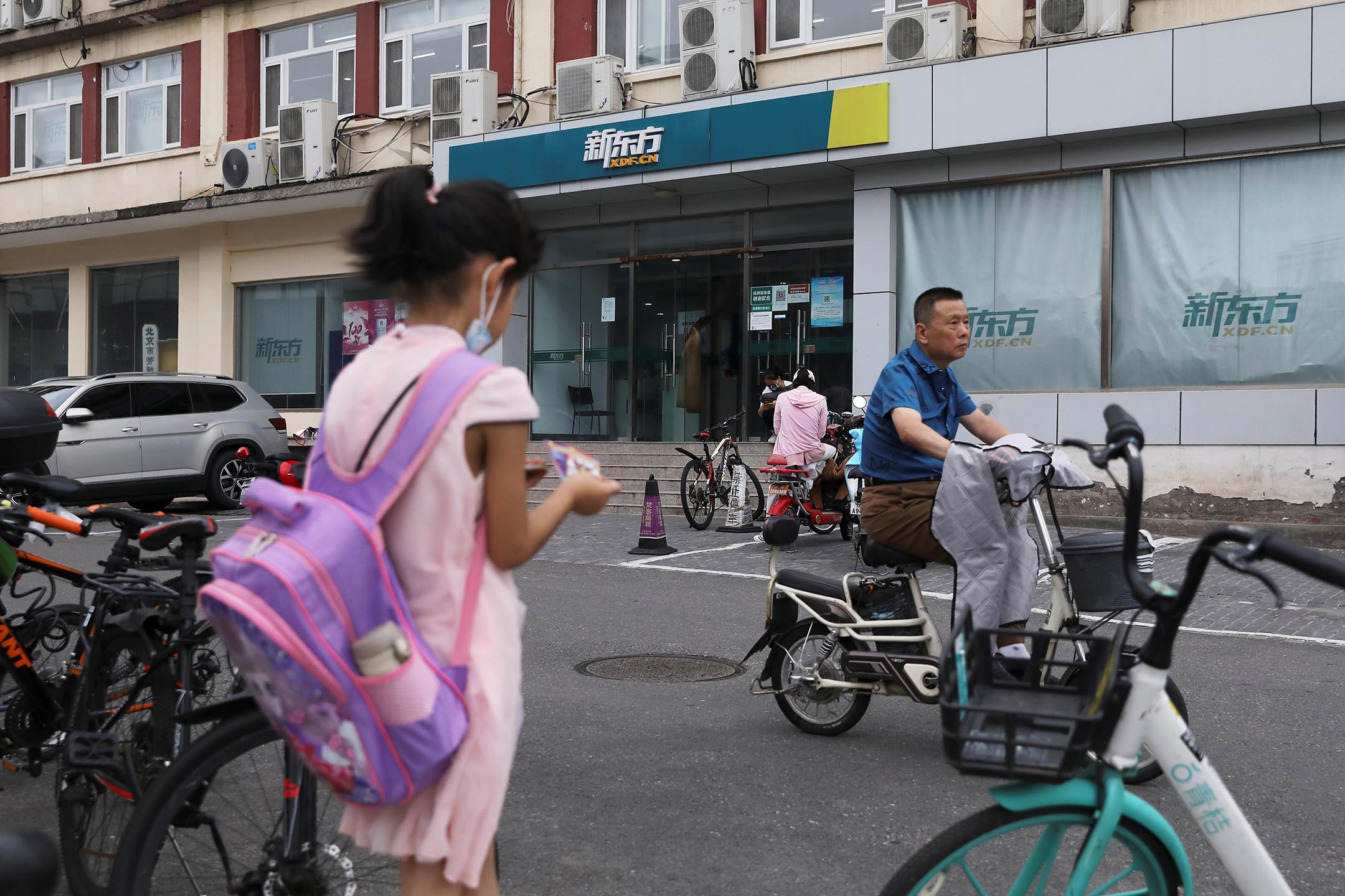 2021年7月26日中国北京，一名背著书包的女孩站在新东方教育科技集团的一家店附近。