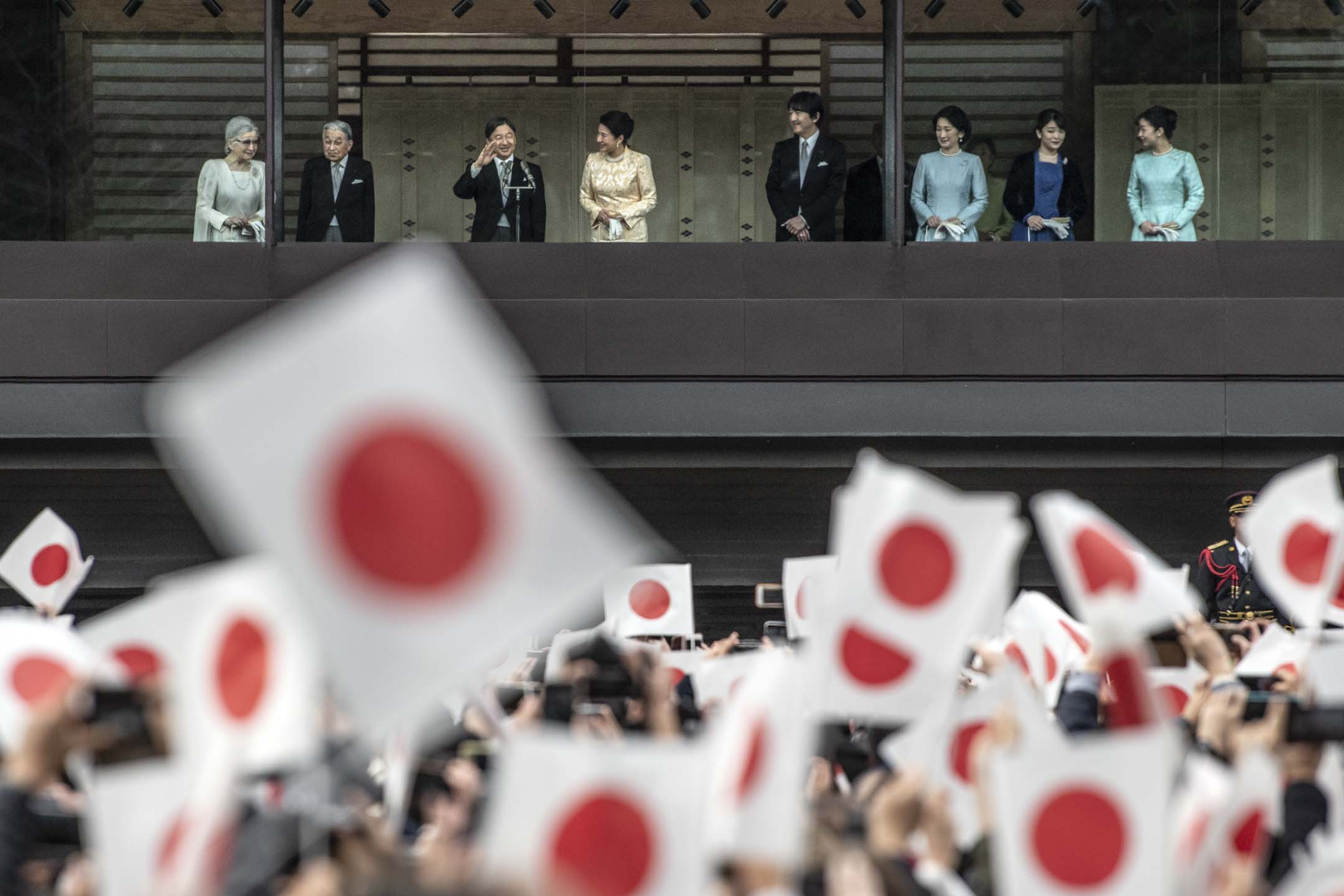 2020年1月2日，日本德仁天皇與皇室人員在東京皇居致以傳統新年問候後，祝福者揮舞旗幟。