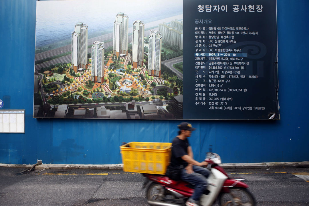 2010年9月3日，一名男子骑着电单车经过韩国首尔一处建筑工地。